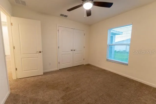 an empty room with chandelier fan