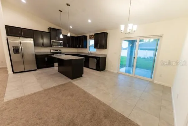 a large kitchen with a large counter top stainless steel appliances and cabinets