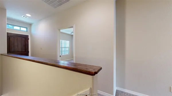 a view of a hallway with wooden floor and front door