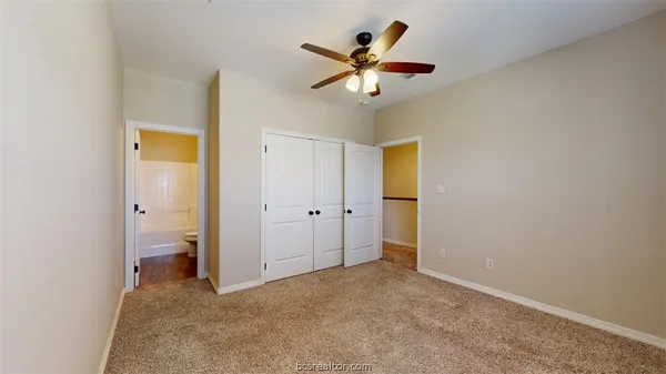 a view of a livingroom with a chandelier fan and a bathroom