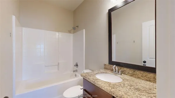 a bathroom with a granite countertop sink toilet and shower