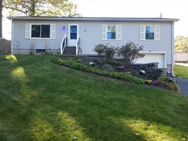 a front view of house with a garden