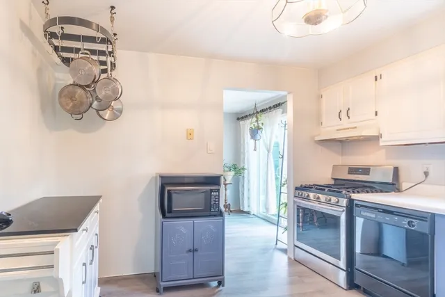 a kitchen with granite countertop a stove and a wooden floor