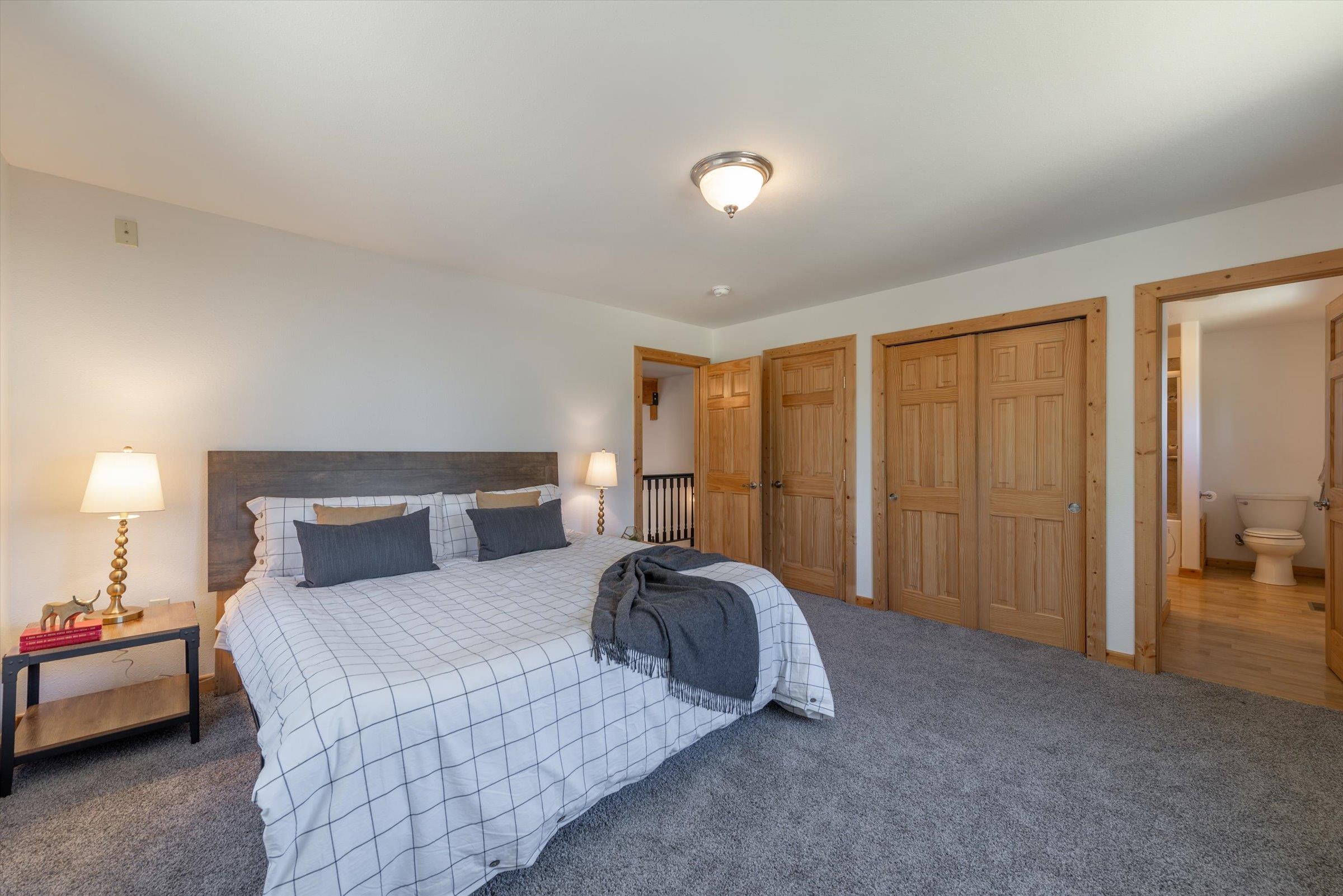 10309 Evensham Place Truckee, CA 96161 - Photo 14 of 21 a spacious bedroom with a bed and a lamp with window
