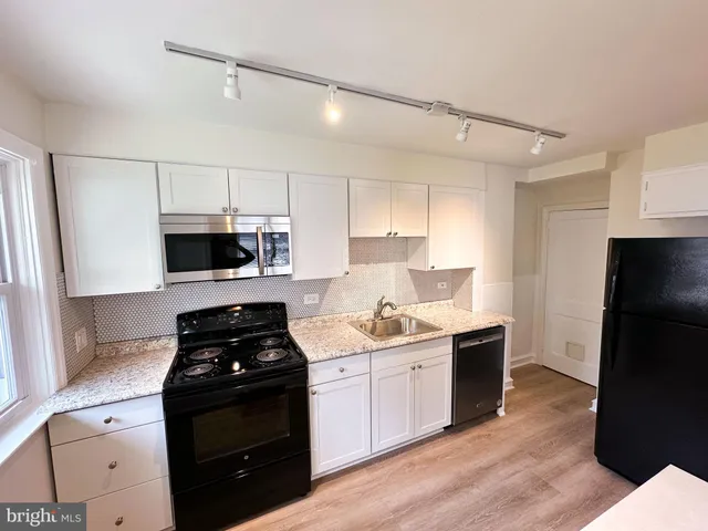 a kitchen with a sink stainless steel appliances and cabinets