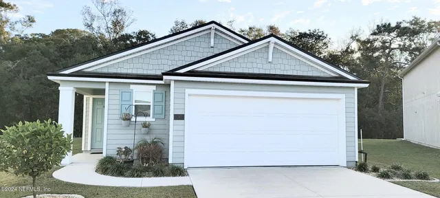 a front view of a house with a yard and trees