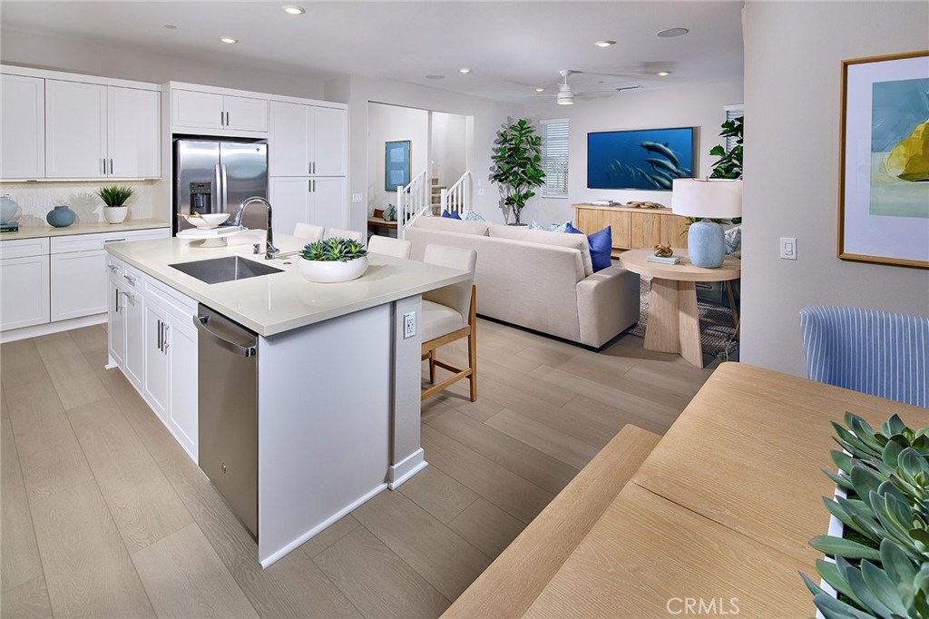 12716 Rosemount Road Eastvale, CA 92880 - Photo 6 of 22 a living room with stainless steel appliances kitchen island furniture and a wooden floor
