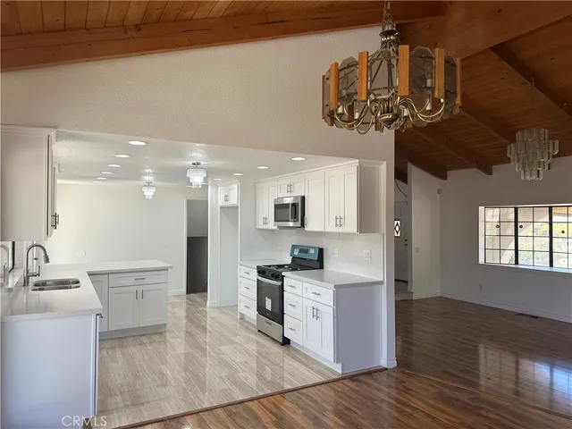 a kitchen with stainless steel appliances granite countertop a sink and wooden floor