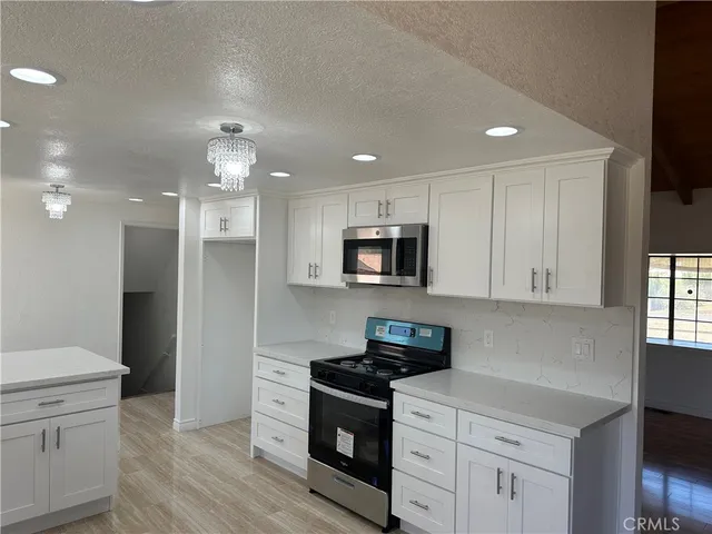 a kitchen with stainless steel appliances granite countertop a sink a stove a refrigerator and cabinets