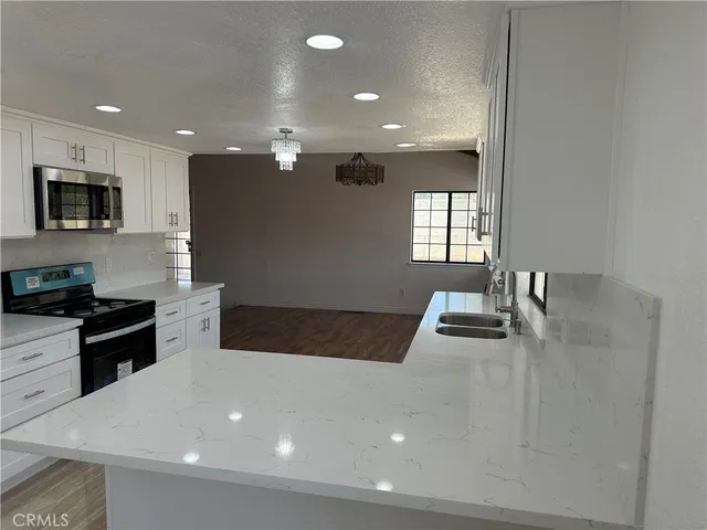 a large kitchen with stainless steel appliances a large counter top a stove and a refrigerator