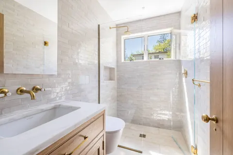 a bathroom with a sink a toilet and shower