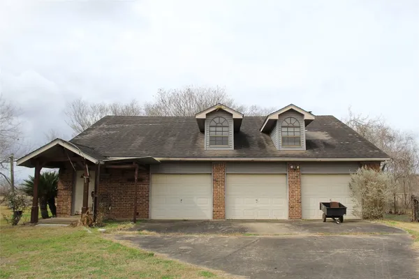 a view of a white house with large windows and a small yard