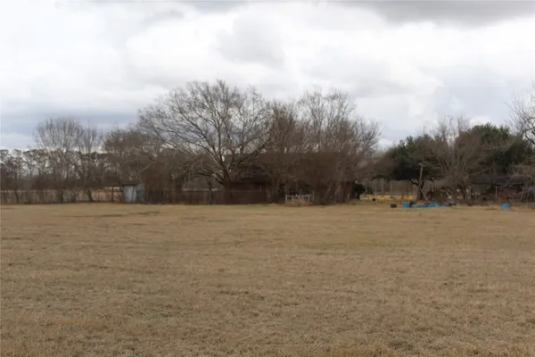a view of a field with trees in background