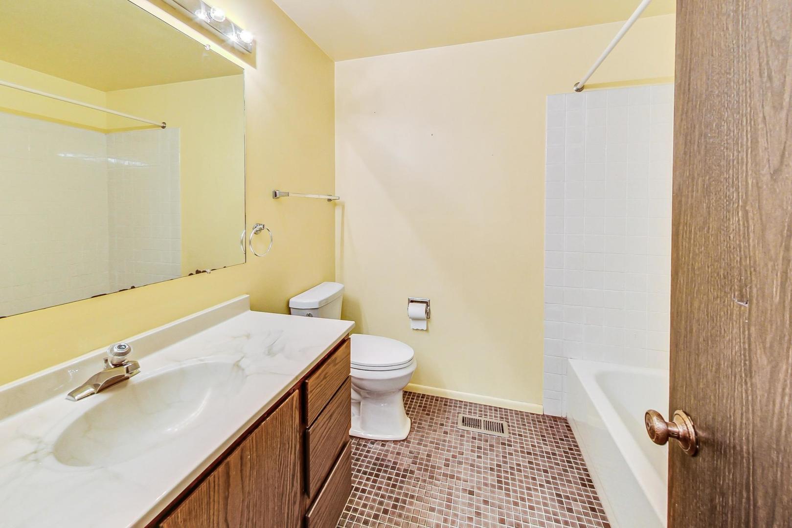2980 Northampton Drive, Unit D1 Rolling Meadows, IL 60008 - Photo 24 of 35 a bathroom with a sink a toilet and shower
