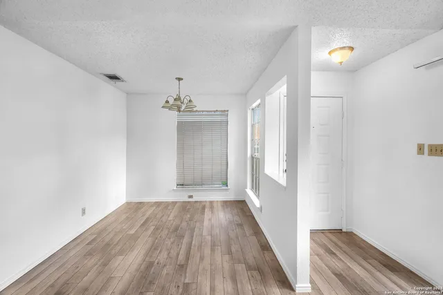 a view of a room with wooden floor and window
