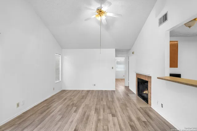 a view of a room with wooden floor and a fireplace