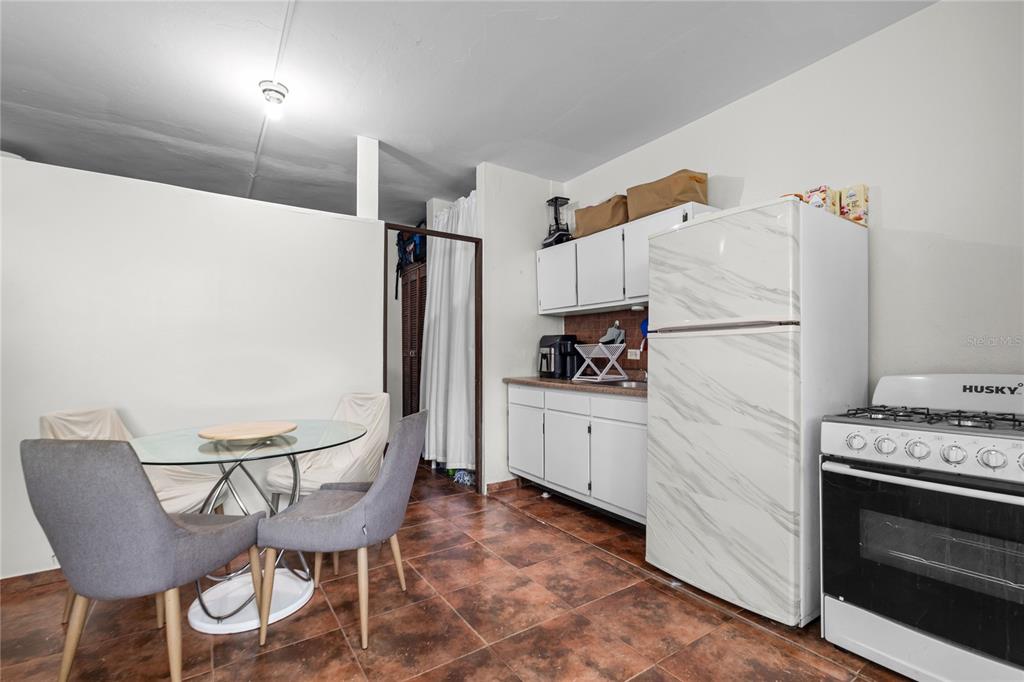 228 Calle 25 Guaynabo, Guaynabo 00969 - Photo 3 of 10 a kitchen with stainless steel appliances a refrigerator a stove a dining table and chairs