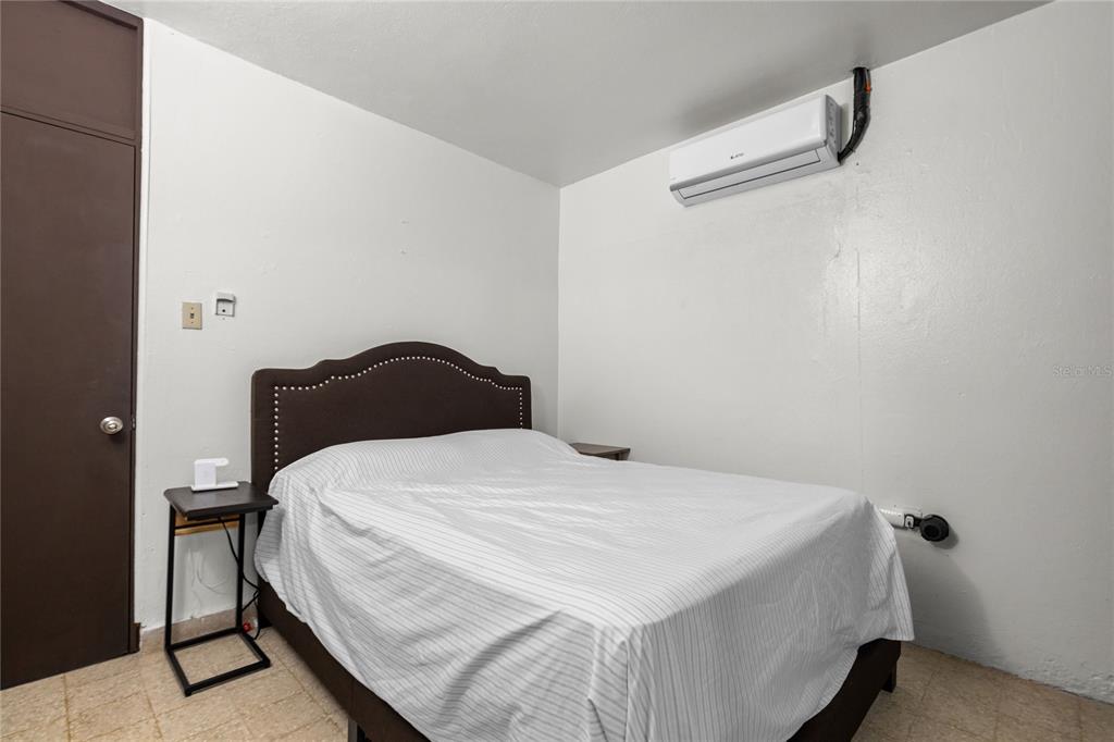 228 Calle 25 Guaynabo, Guaynabo 00969 - Photo 4 of 10 a bedroom with a bed and a night stand