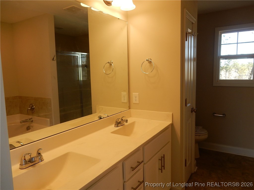111 South Dakota Court Spring Lake, NC 28390 - Photo 17 of 29 a bathroom with a granite countertop sink toilet and shower