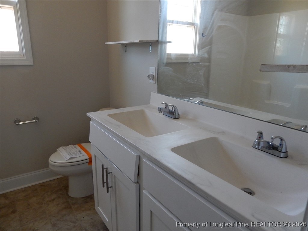 111 South Dakota Court Spring Lake, NC 28390 - Photo 22 of 29 a bathroom with a sink a toilet and vanity