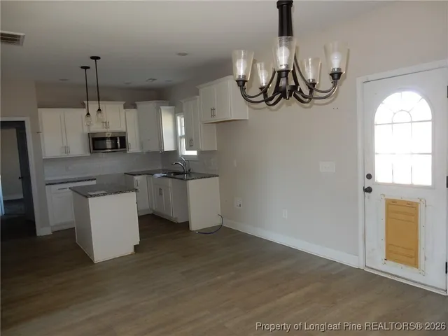 a kitchen with kitchen island granite countertop wooden cabinets and a stainless steel appliances