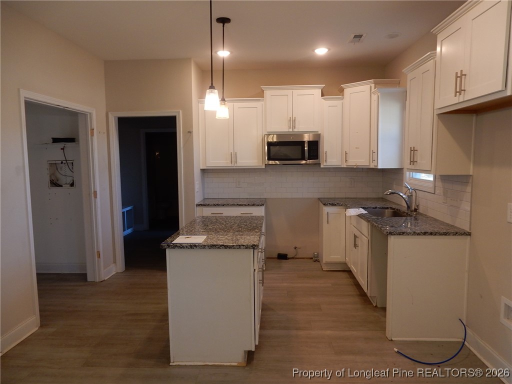 111 South Dakota Court Spring Lake, NC 28390 - Photo 6 of 29 a kitchen with kitchen island granite countertop wooden cabinets and a stainless steel appliances