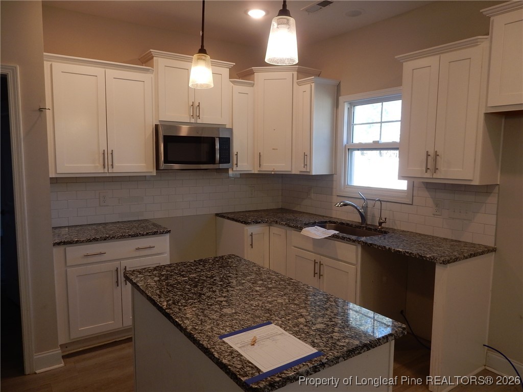 111 South Dakota Court Spring Lake, NC 28390 - Photo 7 of 29 a kitchen with stainless steel appliances granite countertop a sink stove and microwave