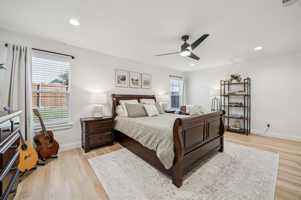 1609 Knight Trail Little Elm, TX 75036 - Photo 13 of 28 a spacious bedroom with a bed a dresser and a large window