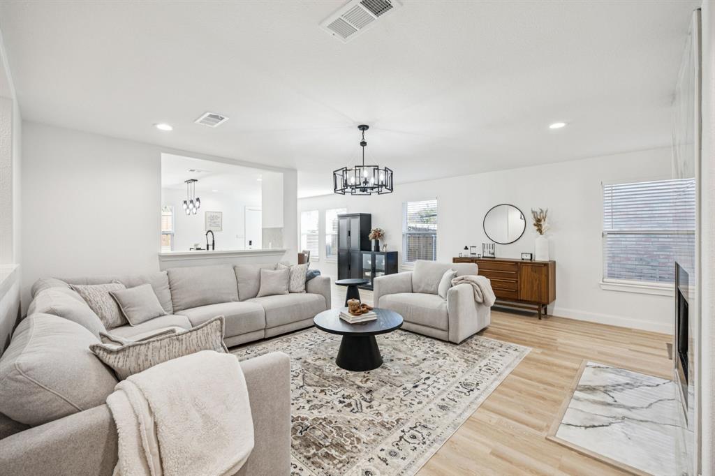 1609 Knight Trail Little Elm, TX 75036 - Photo 4 of 28 a living room with furniture a chandelier and a rug