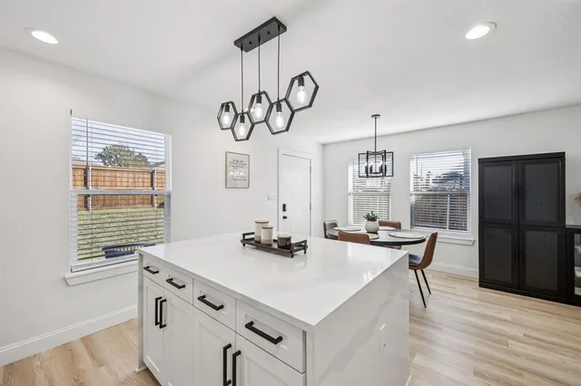 a kitchen with a table chairs stove and wooden floor
