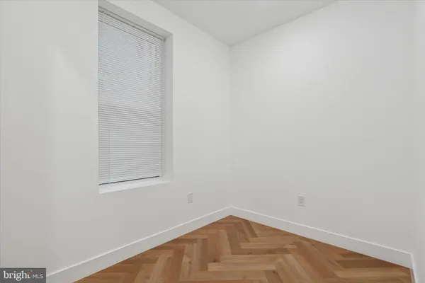 a view of a small space with wooden floor and a window