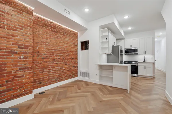a large white kitchen with stainless steel appliances