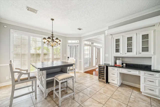 a large kitchen with granite countertop a stove a table and chairs in it