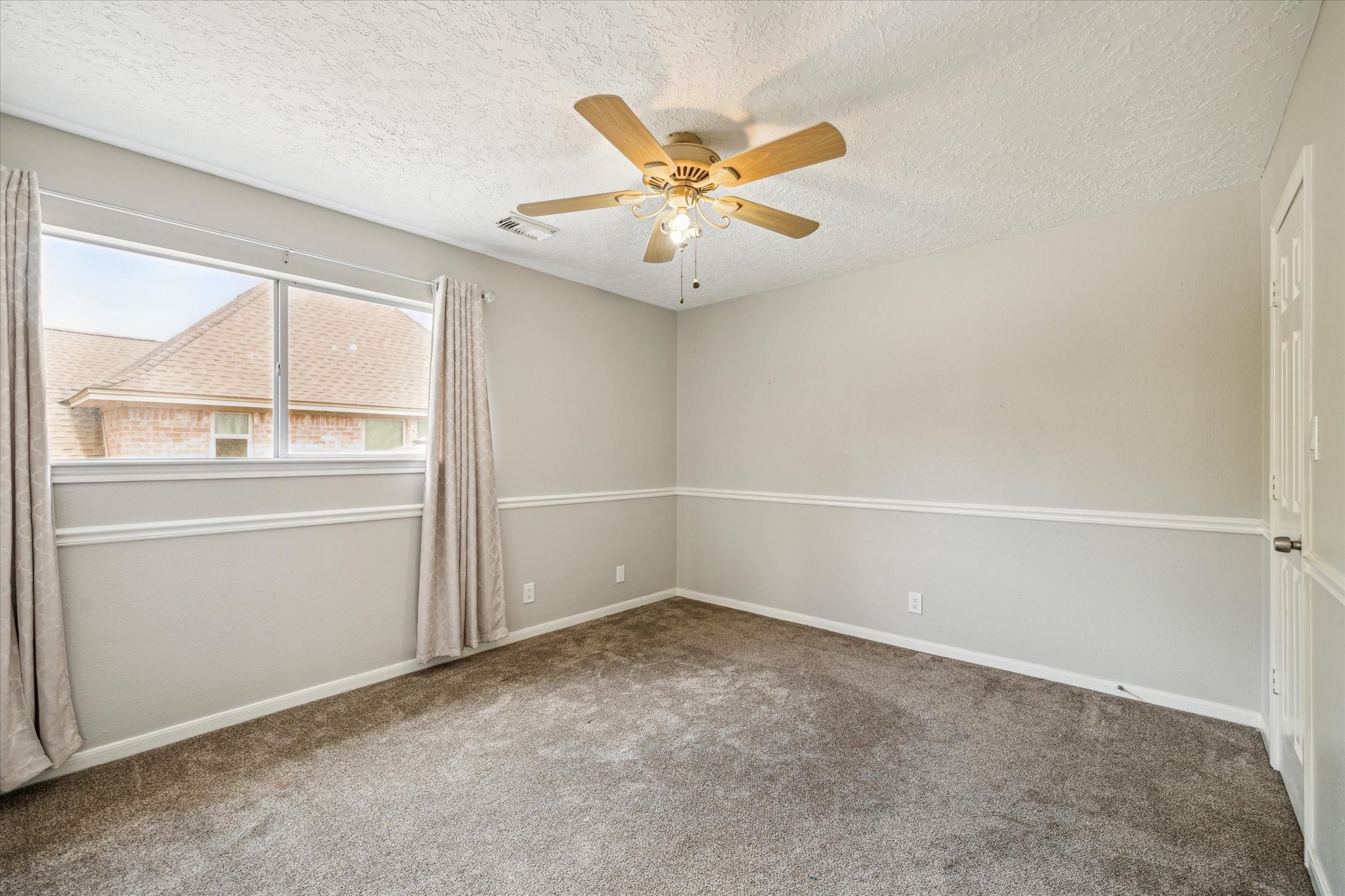 15314 Ripplewind Lane Houston, TX 77068 - Photo 17 of 24 an empty room with a ceiling fan and window