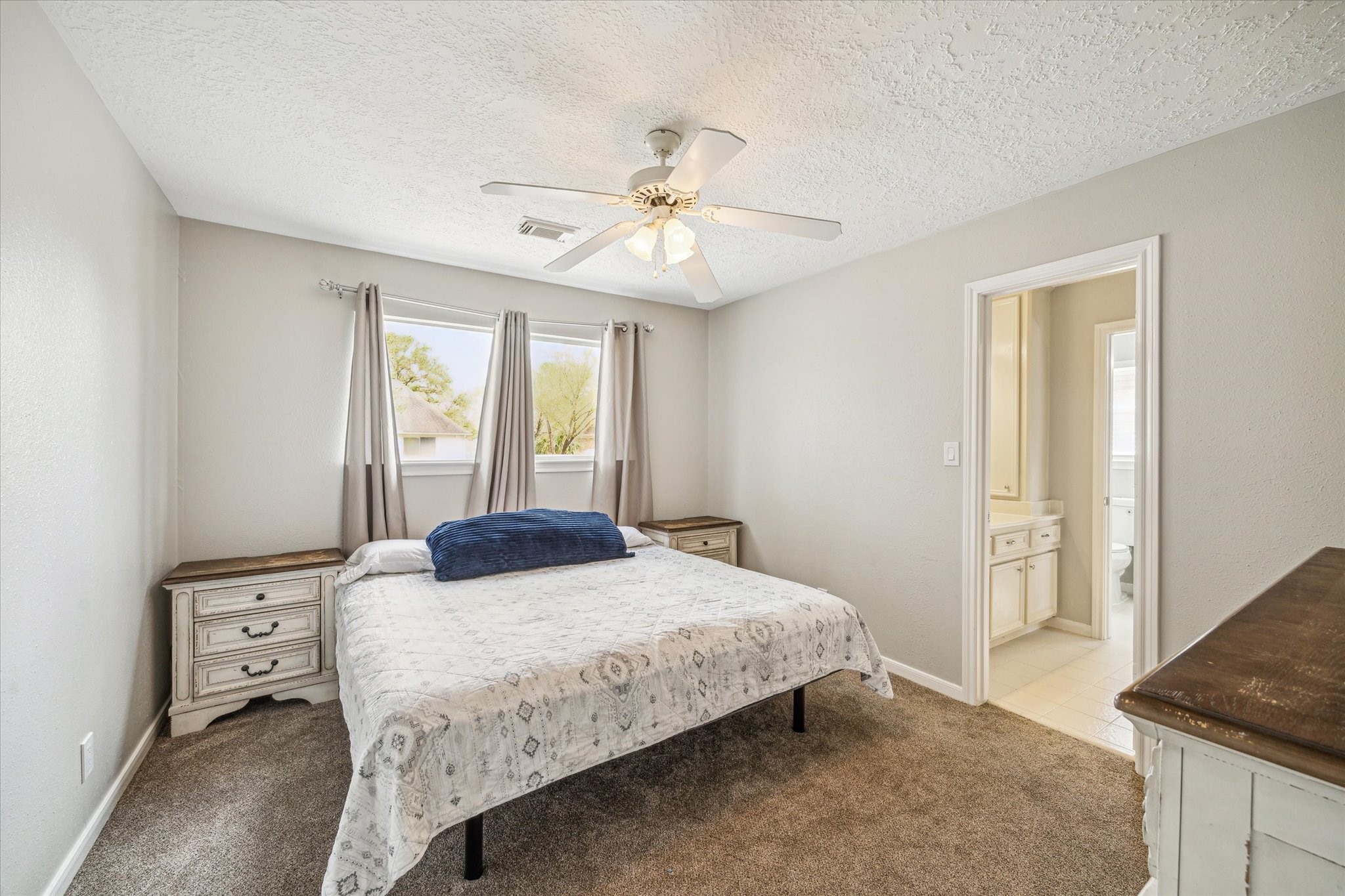 15314 Ripplewind Lane Houston, TX 77068 - Photo 18 of 24 a bedroom with a bed and a chandelier