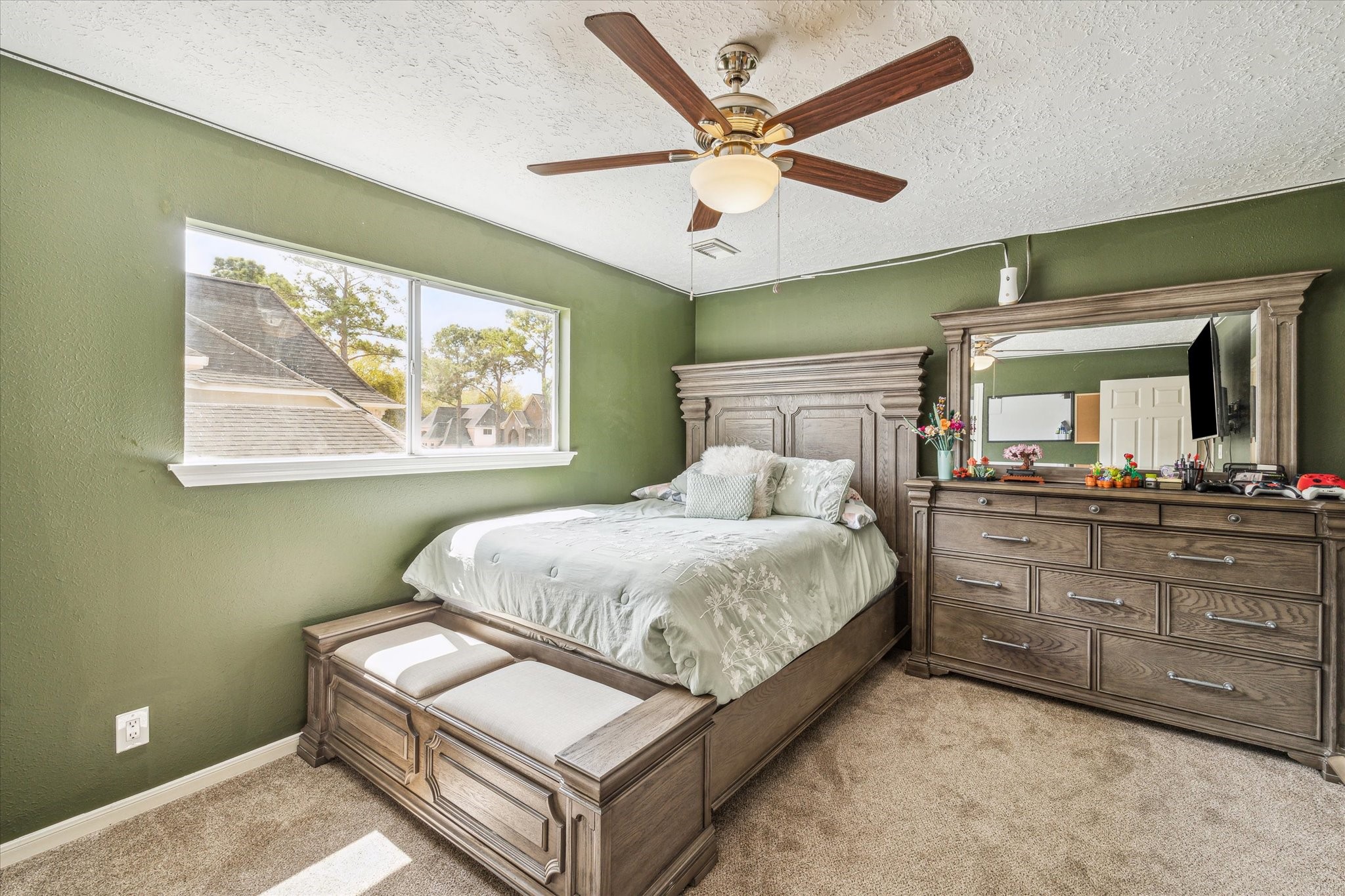 15314 Ripplewind Lane Houston, TX 77068 - Photo 19 of 24 a bedroom with a large bed and a chandelier