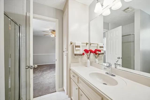 a bathroom with a shower sink vanity and mirror