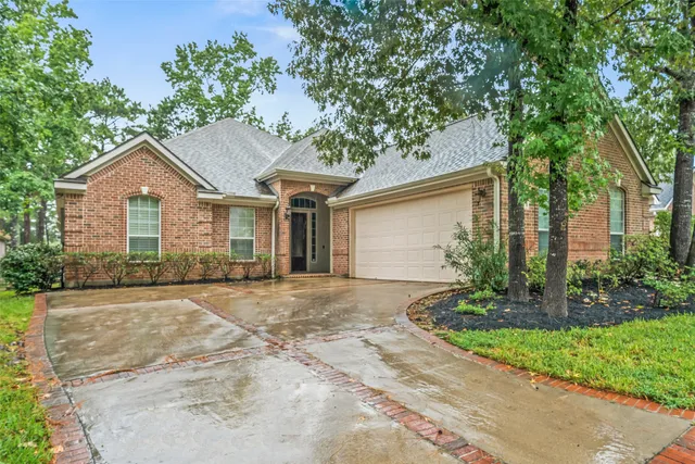 a front view of a house with a garden and trees