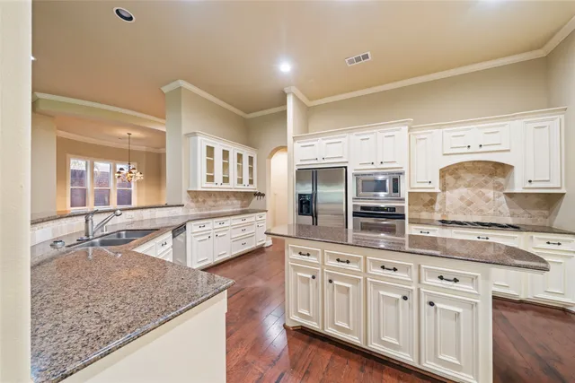 a kitchen with stainless steel appliances granite countertop a sink and dishwasher stove with wooden floor