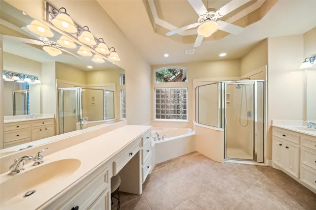 a spacious bathroom with a double vanity sink a large mirror and shower