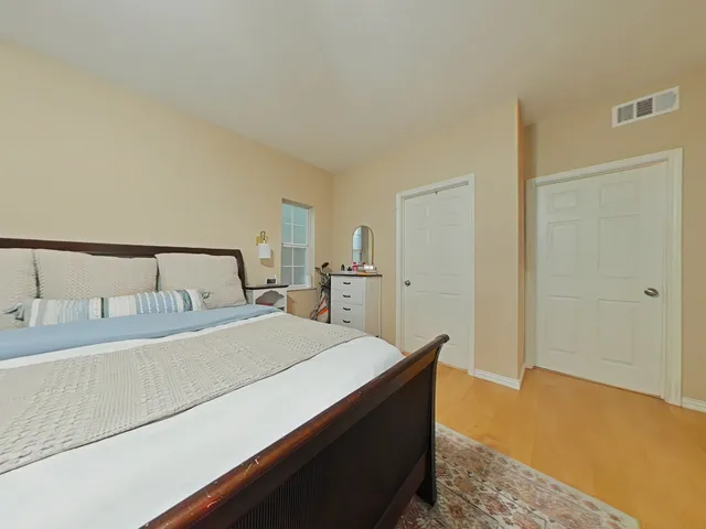 a bedroom with a bed and wooden floor