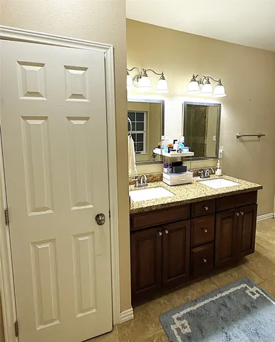 a bathroom with a double vanity sink and a mirror