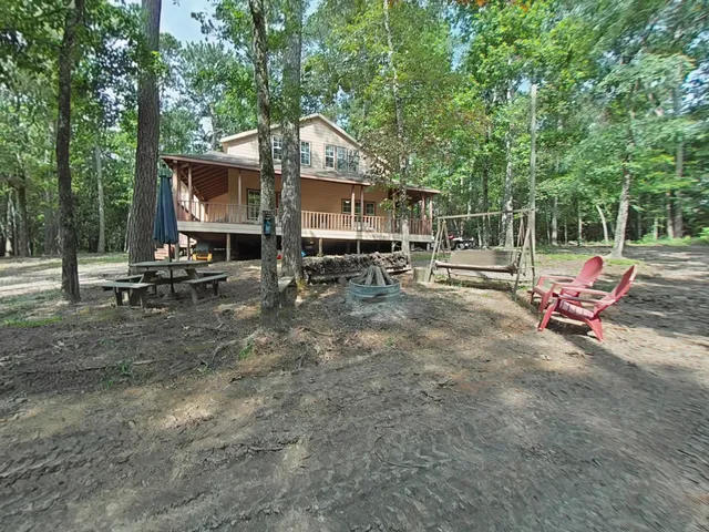 a view of a park with chairs and wooden fence