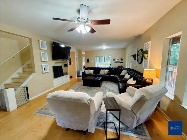 a living room with furniture a flat screen tv and kitchen view