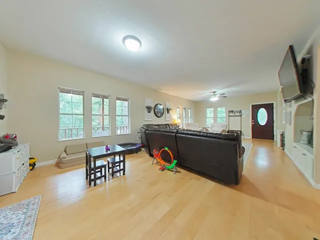 a living room with furniture a flat screen tv and a table