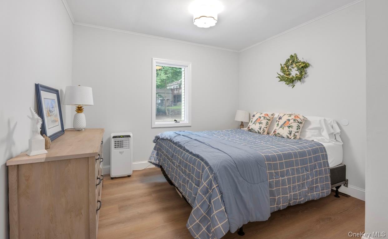 164 Maple Road Wading River, NY 11792 - Photo 14 of 19 Bedroom featuring light wood finished floors and crown molding