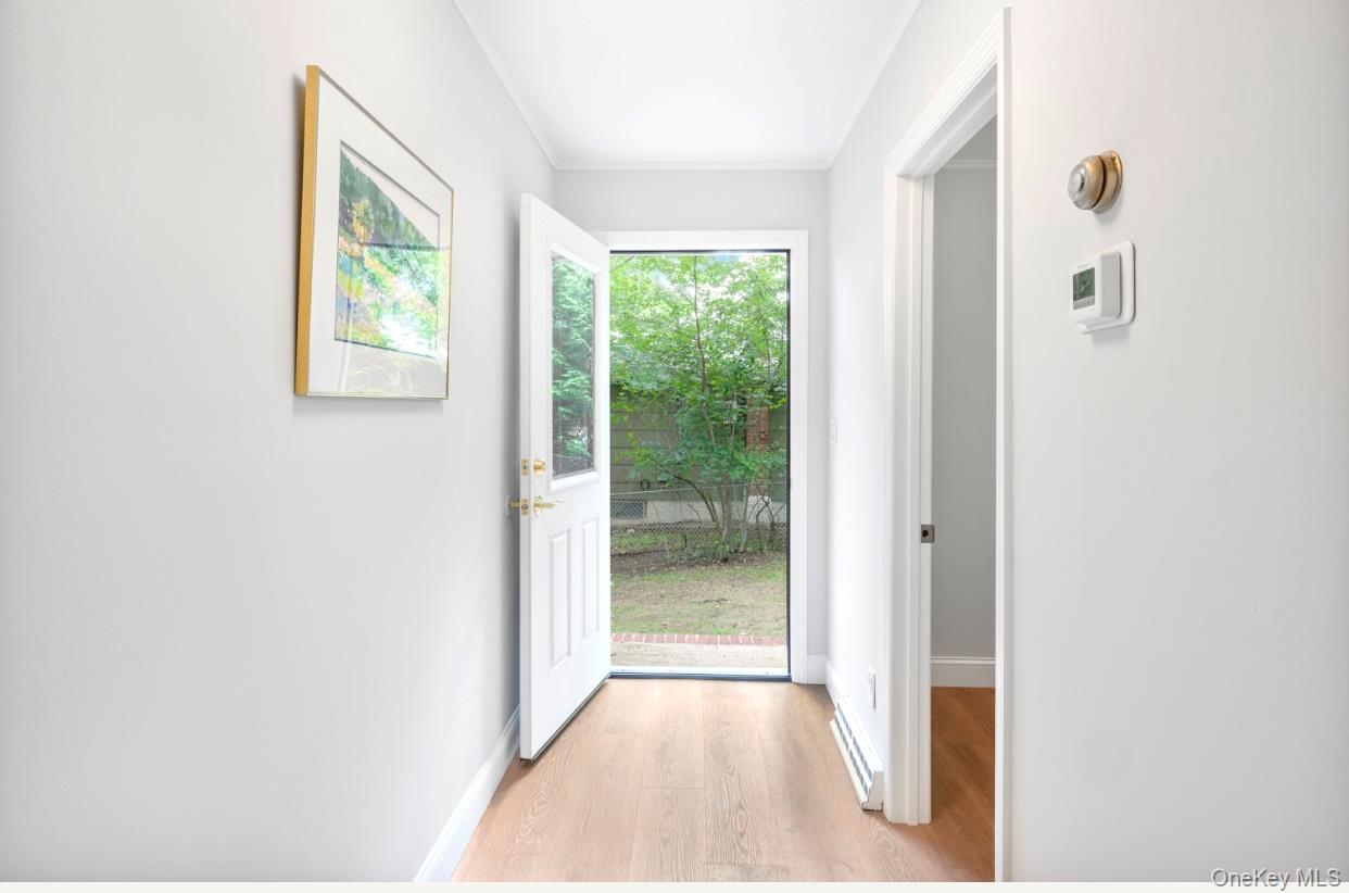 164 Maple Road Wading River, NY 11792 - Photo 17 of 19 Doorway to outside with wood finished floors and ornamental molding