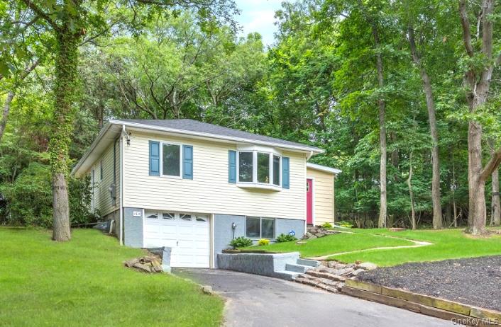 164 Maple Road Wading River, NY 11792 - Photo 2 of 19 View of front of home with a front lawn, asphalt driveway, an attached garage, and view of scattered trees