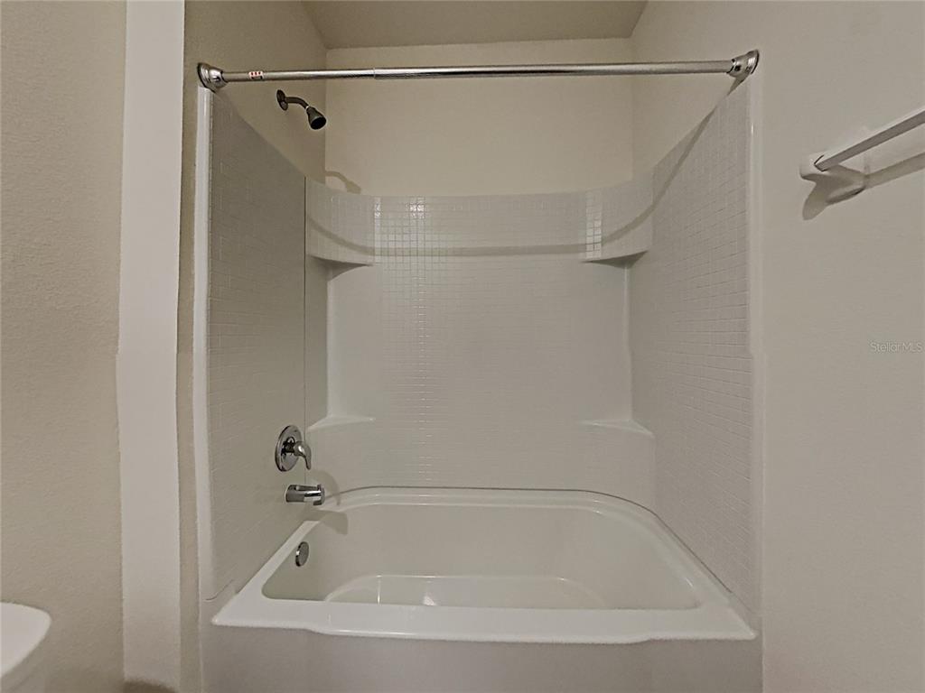 30985 Penny Surf Loop Wesley Chapel, FL 33545 - Photo 13 of 15 a bathroom with a shower and a bath tub