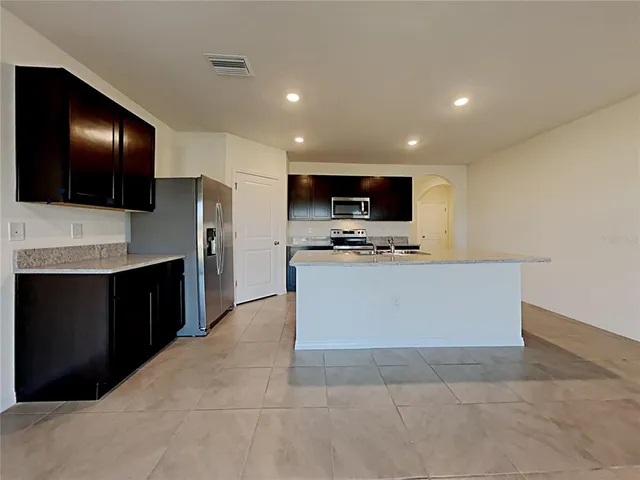 a view of kitchen with stainless steel appliances cabinets